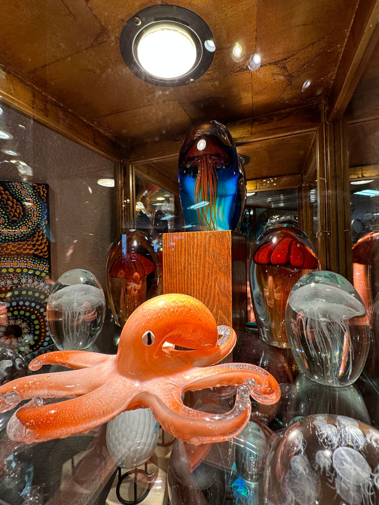 Blown glass pieces featuring an octopus and various jellyfish paperweights