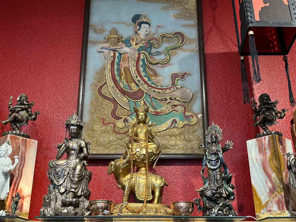 Asian Princess Painting above buddha statuettes