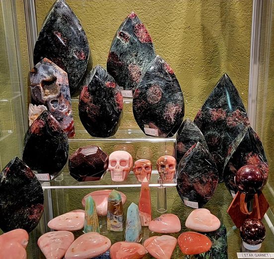 Black and pink crystals in display case with skull carvings and puffy hearts